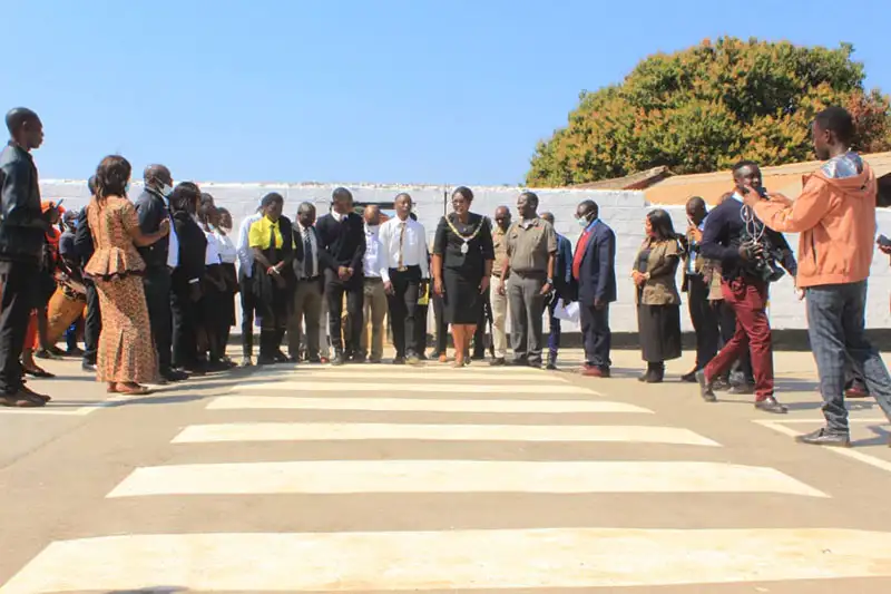 Kitwe Mayor Mpansa Mwaya crosses the newly installed zebra crossing at Chimwemwe Secondary School.